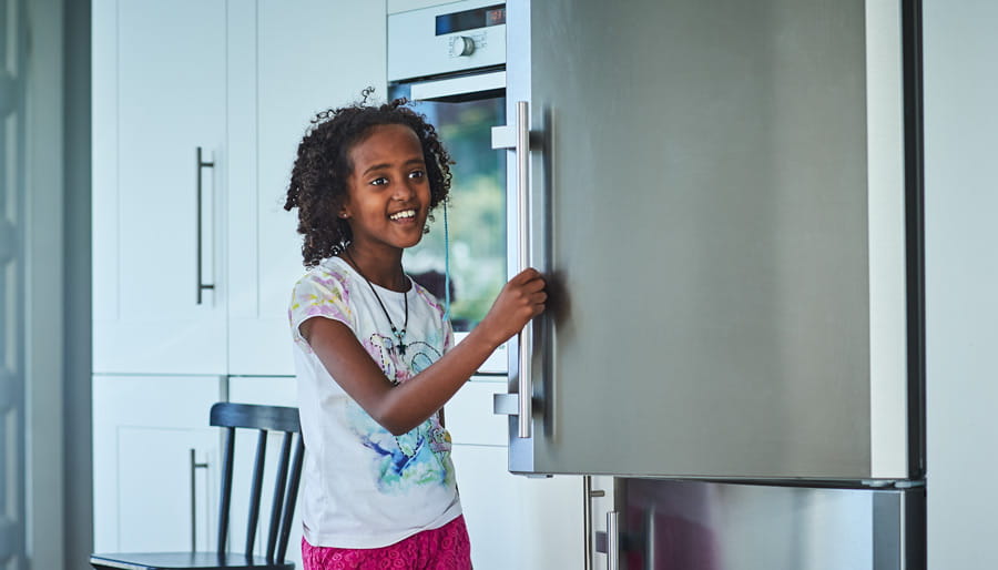 happy girl opening fridge