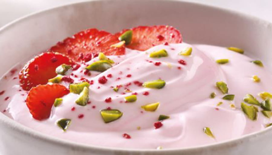 Yogurt in bowl with strawberry and pistachio