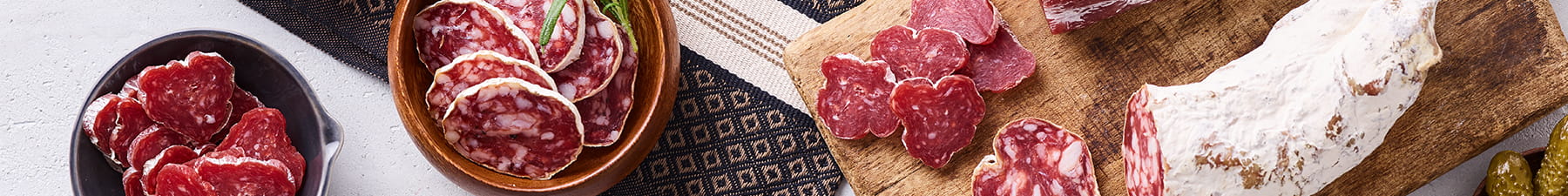 Sliced salami on wooden board