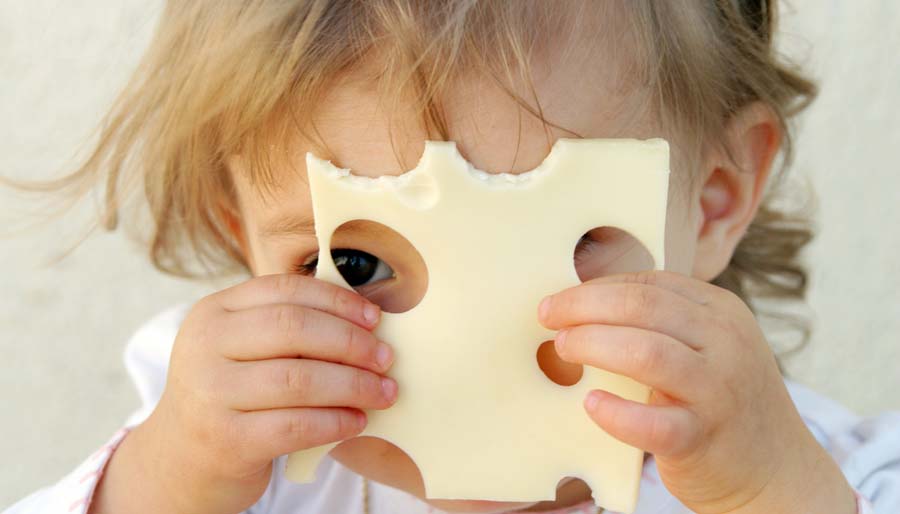 child looking through hole in cheese