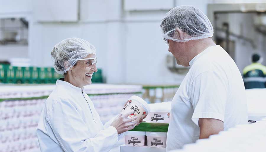 Two workers standing beside FRESHQ products