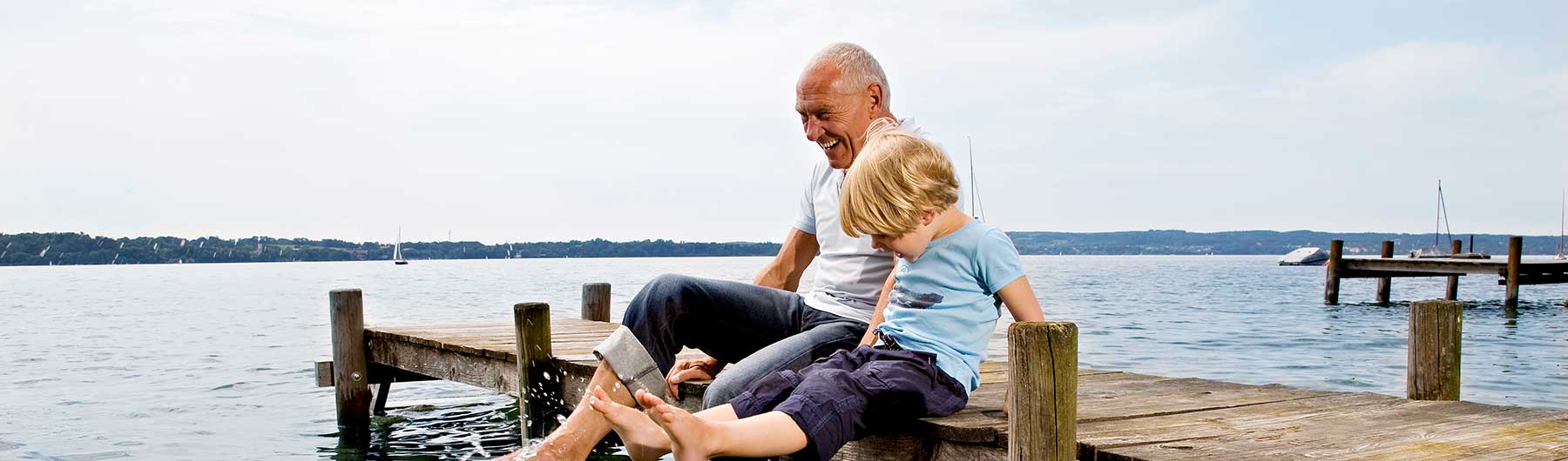 Elderly-man-and-boy-with-feet-in-water