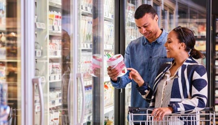 Consumers in supermarket looking at yogurt